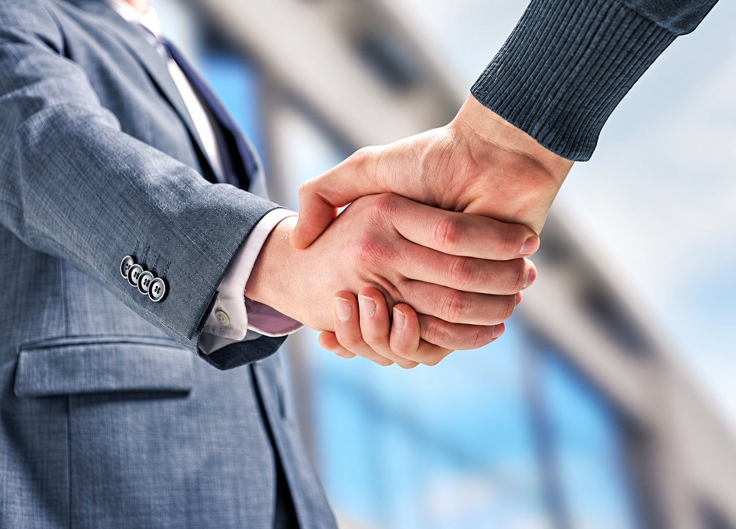 Poignée de main entre un homme en costume gris et un partenaire